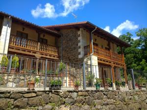 ein Haus mit einem Zaun davor in der Unterkunft Viviendas Rurales Aldea de Dosamantes in Pesaguero-La Parte