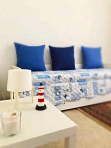łóżko z niebieskimi poduszkami oraz stół z lampką w obiekcie Carpenino's home w mieście La Spezia