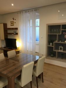 a dining room with a wooden table and white chairs at Apartment Bacvice in Split