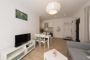 ein Wohnzimmer mit einem Sofa, einem TV und einem Tisch in der Unterkunft Plitvice Retreat Apartments in Rudanovac