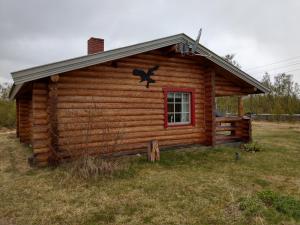 Cabaña de madera con ventana roja y techo en Johansens hytteutleie en Tana