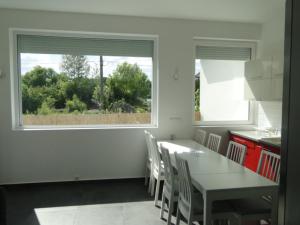 a kitchen with a table and chairs and a window at LazaApartman in Nyíregyháza