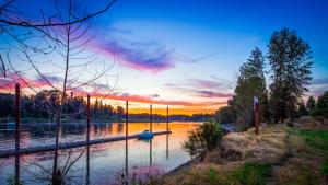 un coucher de soleil sur une rivière avec un bateau dans l'eau dans l'établissement Best Western Plus Rivershore Hotel, à Oregon City