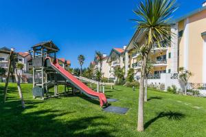 un parque infantil con un tobogán y una palmera en Prime Apartment Beloura, en Sintra