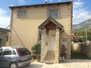 a car parked in front of a house with a door at Apartman Nadia in Karlobag