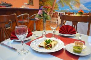 uma mesa com um prato de comida e dois copos de vinho em Hotel Caribe Panamá na Cidade do Panamá