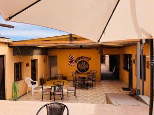 an outdoor patio with tables and chairs and an umbrella at Hostal Intipara in San Pedro de Atacama