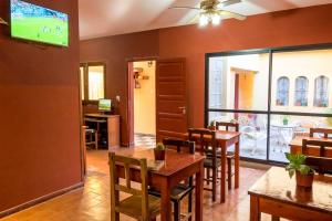a dining room with tables and chairs and a tv at Hostal Alamo in Cafayate