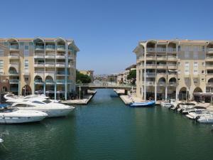 un gruppo di imbarcazioni ormeggiate in un canale accanto agli edifici di Appartement Port Fréjus avec Loggia et accès Plages à pieds a Fréjus