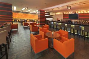 a restaurant with orange chairs and a bar at Wyndham Garden Guadalajara Acueducto in Guadalajara