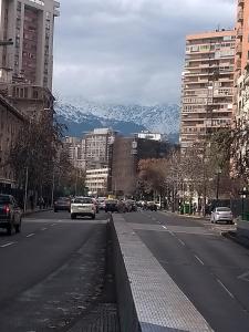 a city street with cars driving down a street with mountains at Kingui in Santiago