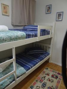 two bunk beds in a room with a rug at Apartamento Beira mar in Arroio do Silva