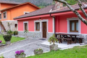 a red house with a picnic table in front of it at casa La Trillera in Tornín