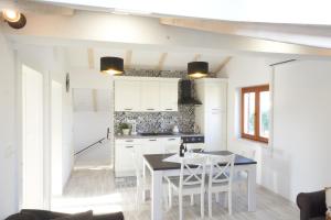 Apartman Balancana في قشتيلا: مطبخ مع دواليب بيضاء وطاولة وكراسي