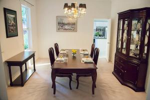 a dining room with a table and chairs and a chandelier at The Inlet Bed & Breakfast in Saanichton