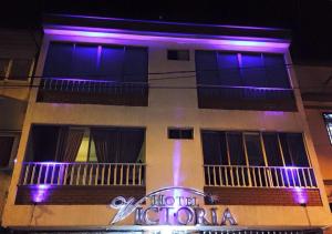 a building with purple lights on the side of it at Hotel Victoria in Chinchiná