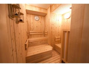 a wooden sauna with a clock on the wall at Y's Hotel Asahikawa Ekimae in Asahikawa