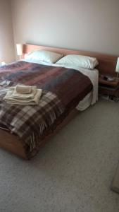 a bedroom with a bed with a blanket and pillows at Minffordd Cottage in Feilding