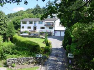 a large white house in the middle of a yard at Lingwood Lodge in Bowness-on-Windermere