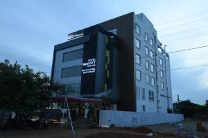 a building with a sign on the side of it at Hotel Smart City Park Inn in Tada
