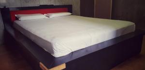 a large white bed with a red head board at Hotel Ravi Mayur International in Chitradurga