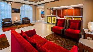 sala de estar con sofá rojo y sillas en Best Western Ft Lauderdale I-95 Inn, en Fort Lauderdale