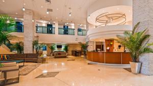 a lobby with couches and palm trees in a building at Best Western Plus Atlantic Beach Resort in Miami Beach