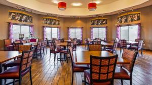 a dining room with tables and chairs and windows at Best Western Plus Carousel Inn & Suites Burlington in Burlington