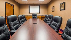a conference room with a wooden table and black chairs at Best Western Plus Carousel Inn & Suites Burlington in Burlington +17 photos