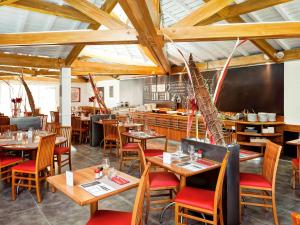 een restaurant met houten tafels en stoelen en een bar bij ibis Lyon Est Bron in Bron