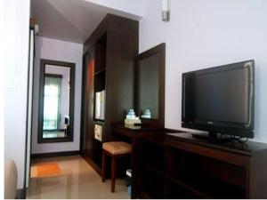 een woonkamer met een televisie op een houten dressoir bij Lanta Bee Garden Bungalow SHA Extra Plus in Koh Lanta