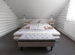 a bedroom with a bed and a ottoman at Csendliget Villas Abádszalók in Abádszalók