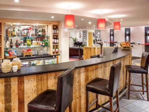 un bar en un restaurante con dos taburetes en ibis Lincoln en Lincoln