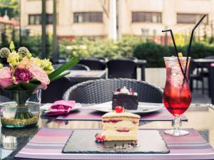 a table with a piece of cake and a drink at Mercure Bucharest City Center in Bucharest