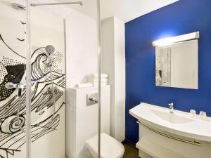 a bathroom with a toilet and a sink at Ibis budget Chambéry Centre Ville- Hôtel Rénové in Chambéry