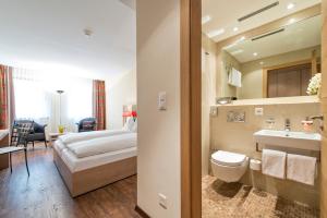 サンモリッツにあるホテル ピッツ サン モリッツのベッドとバスルーム付きのホテルルームです。