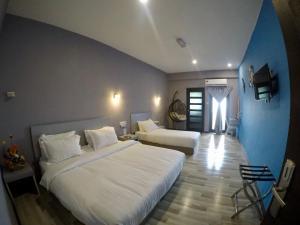 a hotel room with two beds and a window at Ang Lee Holiday Stay in Semporna