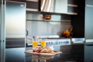 a cutting board with two glasses of orange juice and pastries at Remarkable Lake House in Queenstown