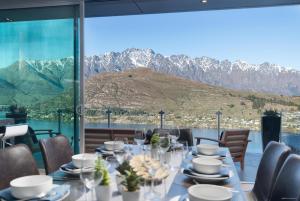 uma sala de jantar com uma mesa e vista para as montanhas em Amazing April May deal em Queenstown