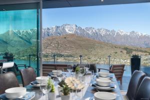 a dining room with a table with a view of mountains at Remarkable Lake House in Queenstown