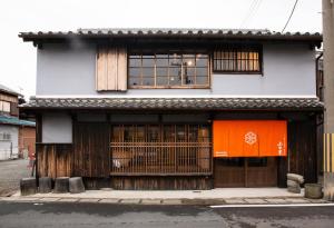 un edificio con puertas y ventanas de madera en una calle en 紀州湯浅古民家町屋宿泊 千山庵 SenzanAn かじやまち301, en Yuasa