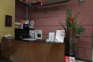 a lobby with a checkout counter with a vase of flowers at Casa Rosario Hotel in Cebu City