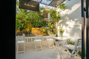 Un patio con mesa y sillas y plantas. en D Central Hoi An Homestay, en Hoi An