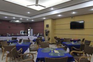 a restaurant with blue tables and chairs and a flat screen tv at Casa Rosario Hotel in Cebu City