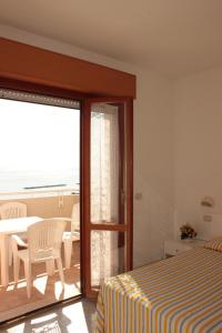 a bedroom with a bed and a view of the ocean at Residence Azzurro in Massignano