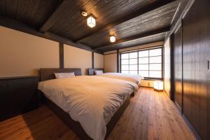 Yuasa的住宿－紀州湯淺古民家町屋宿泊千山庵度假屋，一间卧室设有一张大床和一个窗户。