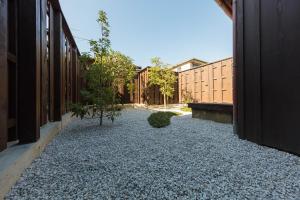 un patio con un camino de grava entre dos edificios en SenzanAn Kitamachi, en Yuasa