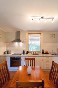 a kitchen with a wooden table and chairs in it at Ruby's Cottage in Penola