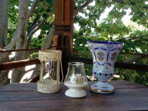 three vases are sitting on a wooden table at House Rodia in Prinos