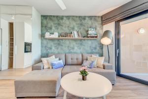 salon z kanapą i stołem w obiekcie Apartamenty Horyzont SeaView by Rent like home w mieście Międzyzdroje